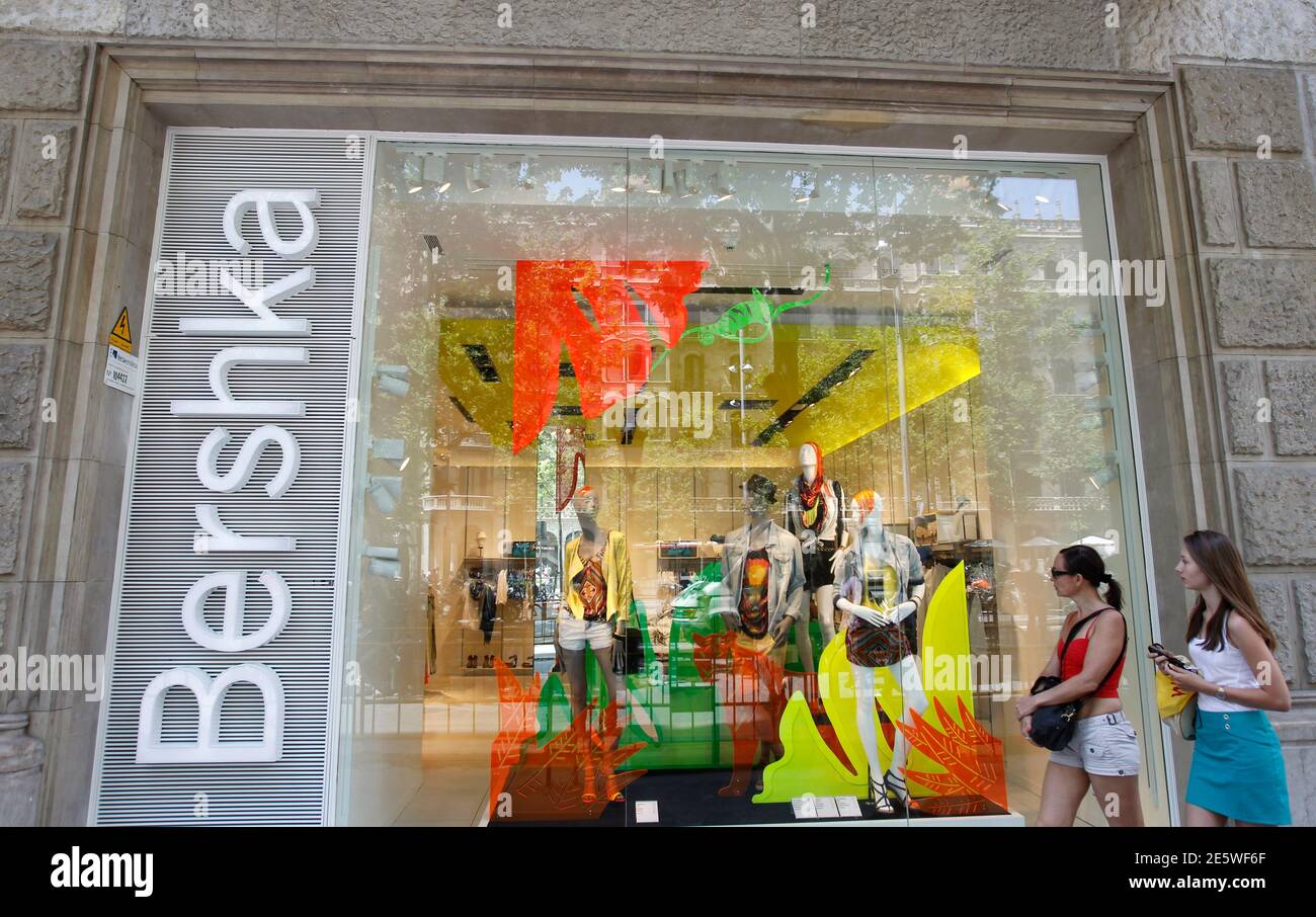 Women look at a shop window of a Bershka store, part of Inditex, in  Barcelona June 13, 2012. Spain's Inditex SA, the world's largest clothes  retailer, bucked Europe's financial crisis with a