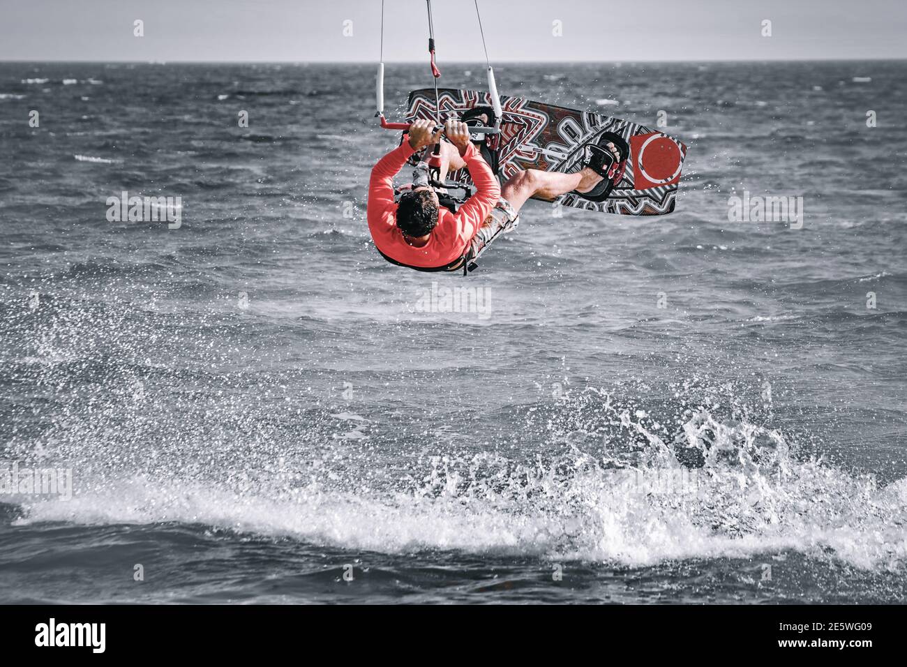 kiteboarder man isolated doing back roll kitesurfing rotation trick kitesurfing boy jumping