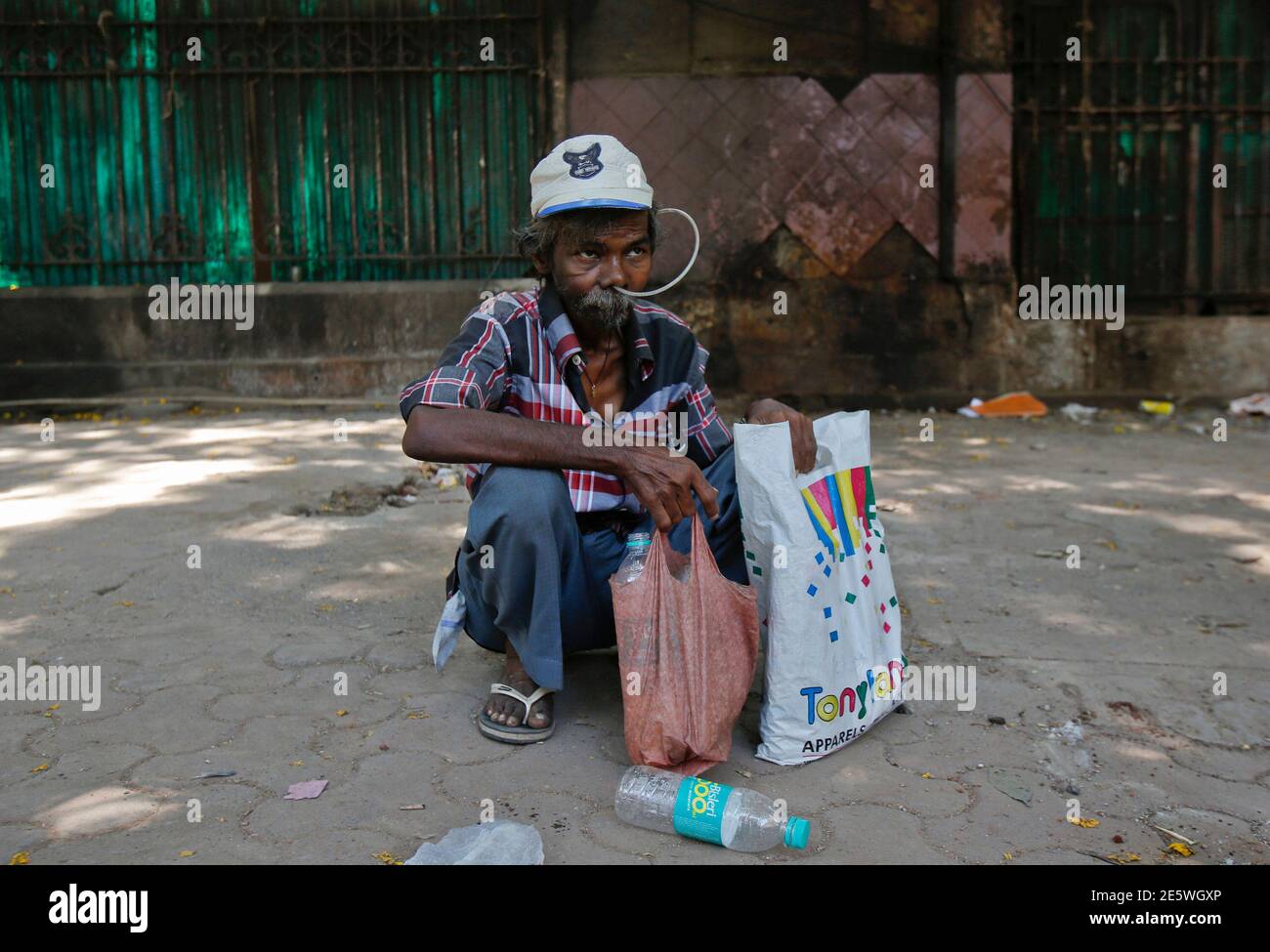 Cancer patient Philip Mokal sits on a pavement outside the Tata Memorial Hospital in Mumbai April 2, 2013. India's top court dismissed Swiss drugmaker Novartis AG's attempt to win patent protection for its cancer drug Glivec, a blow to Western pharmaceutical firms targeting India to drive sales and a victory for local makers of cheap generics. REUTERS/Vivek Prakash (INDIA - Tags: BUSINESS DRUGS SOCIETY HEALTH) Stock Photo