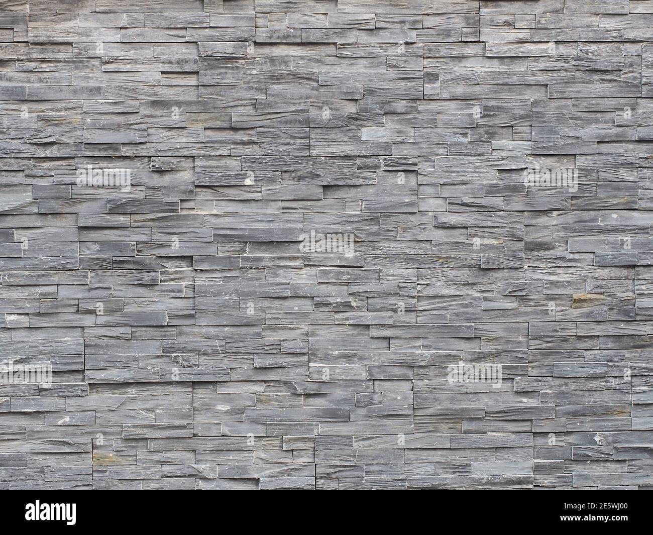 Wall with decorative gray embossed narrow tile cladding Stock Photo