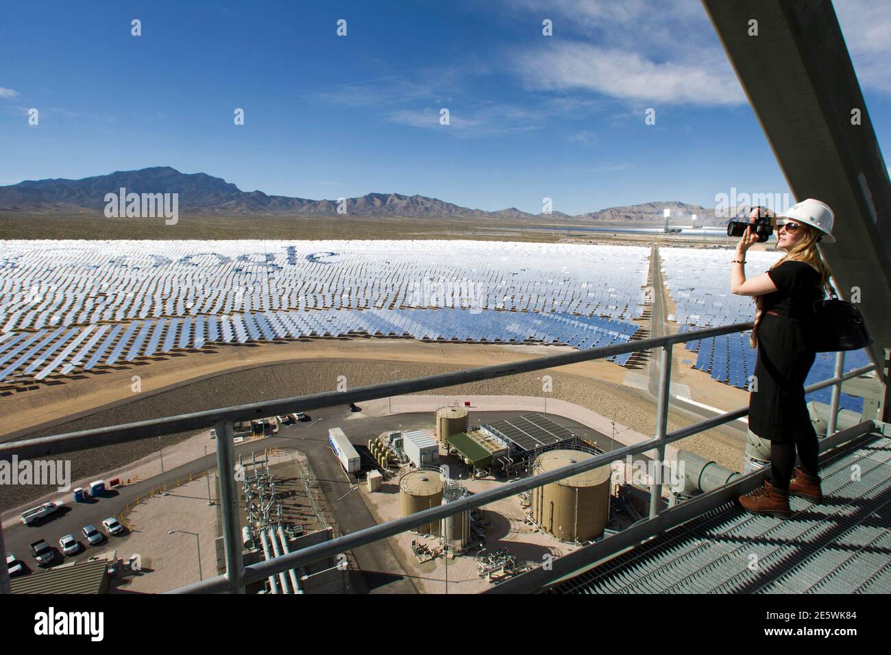 Katie Kukulka, an information officer with the California Energy Commission, takes photos during a tour of the Ivanpah Solar Electric Generating System in the Mojave Desert near the California-Nevada border February 13, 2014. The project, a partnership of NRG, BrightSource, Google and Bechtel, is the world's largest solar thermal facility and uses 347,000 sun-facing mirrors to produce 392 Megawatts of electricity, enough energy to power more than 140,000 homes. REUTERS/Steve Marcus (UNITED STATES - Tags: ENERGY BUSINESS SCIENCE TECHNOLOGY) Stock Photo
