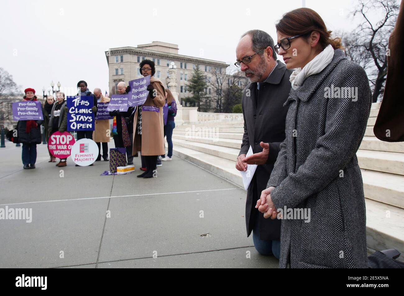 Rev. Patrick Mahoney (2nd R) and Missy Martinez, the National High School Program Coordinator for Students for Life, pray as pro-choice activists (L) rally in front of the U.S. Supreme Court in Washington, January 15, 2014. U.S. Supreme Court justices on Wednesday raised questions about the scope of a Massachusetts law that ensures access for patients at clinics that perform abortions. A majority of the justices at times expressed concerns during the one-hour argument before the high court that the blanket 35-feet (11-meter) no-entry zone around clinics is overly broad.  REUTERS/Yuri Gripas (U Stock Photo