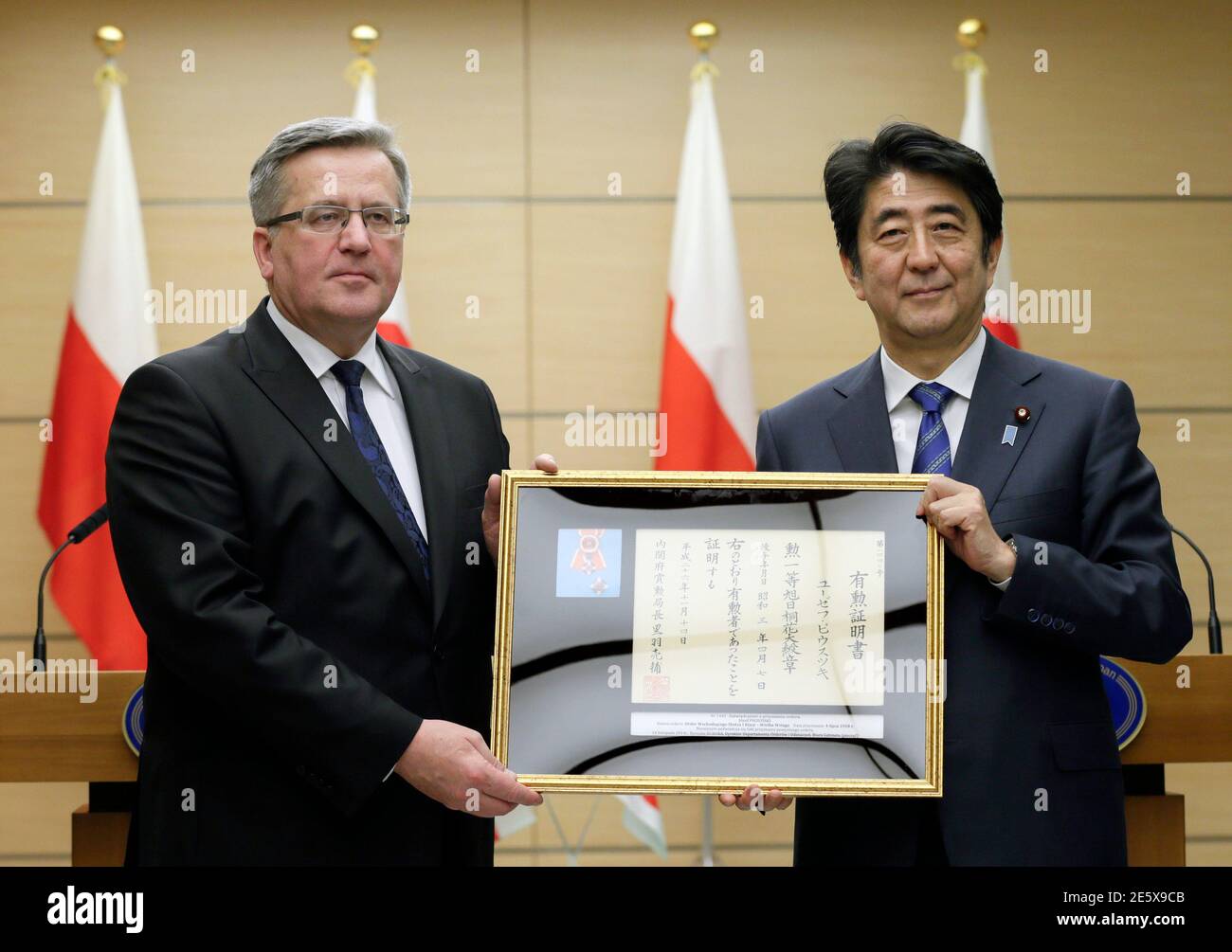Poland's President Bronislaw Komorowski (L) receives the certification for Jozef Pilsudski, who was Chief of State of the Second Polish Republic, from Japan's Prime Minister Shinzo Abe after their joint news conference after their talks at Abe's official residence in Tokyo  February 27, 2015. Pilsudski was decorated the Grand Cordon of the Order of the Rising Sun, Paulownia Flowers, one of highest ranked Japanese decoration by Japan, in 1928. Komorowski is in Japan for a two-day visit. REUTERS/Kimimasa Mayama/Pool (JAPAN - Tags: POLITICS) Stock Photo