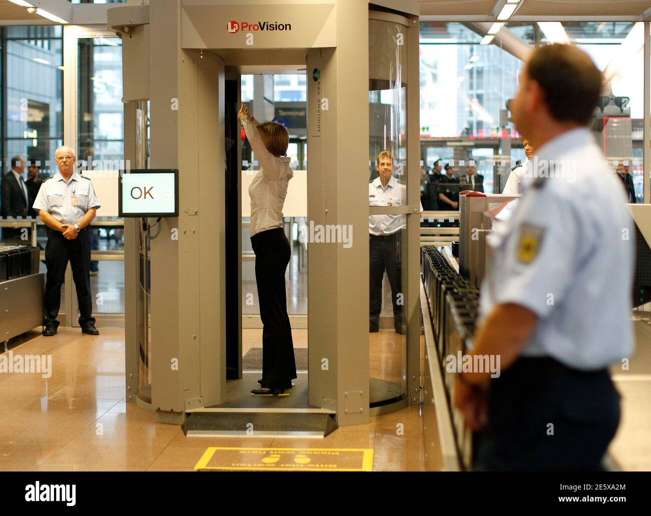 A security official demonstrates a full body scanner during a photocall at  Departure Gate 2 at Hamburg Airport September 27, 2010. Germany started on  Monday the voluntary use of two 'L-3 Provision
