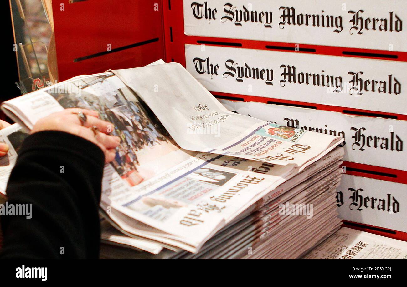 A woman picks up a copy of the Sydney Morning Herald newspaper, a Fairfax  Media publication, in Sydney June 18, 2012. Australia's Fairfax Media,  publisher of some of the country's leading newspapers,