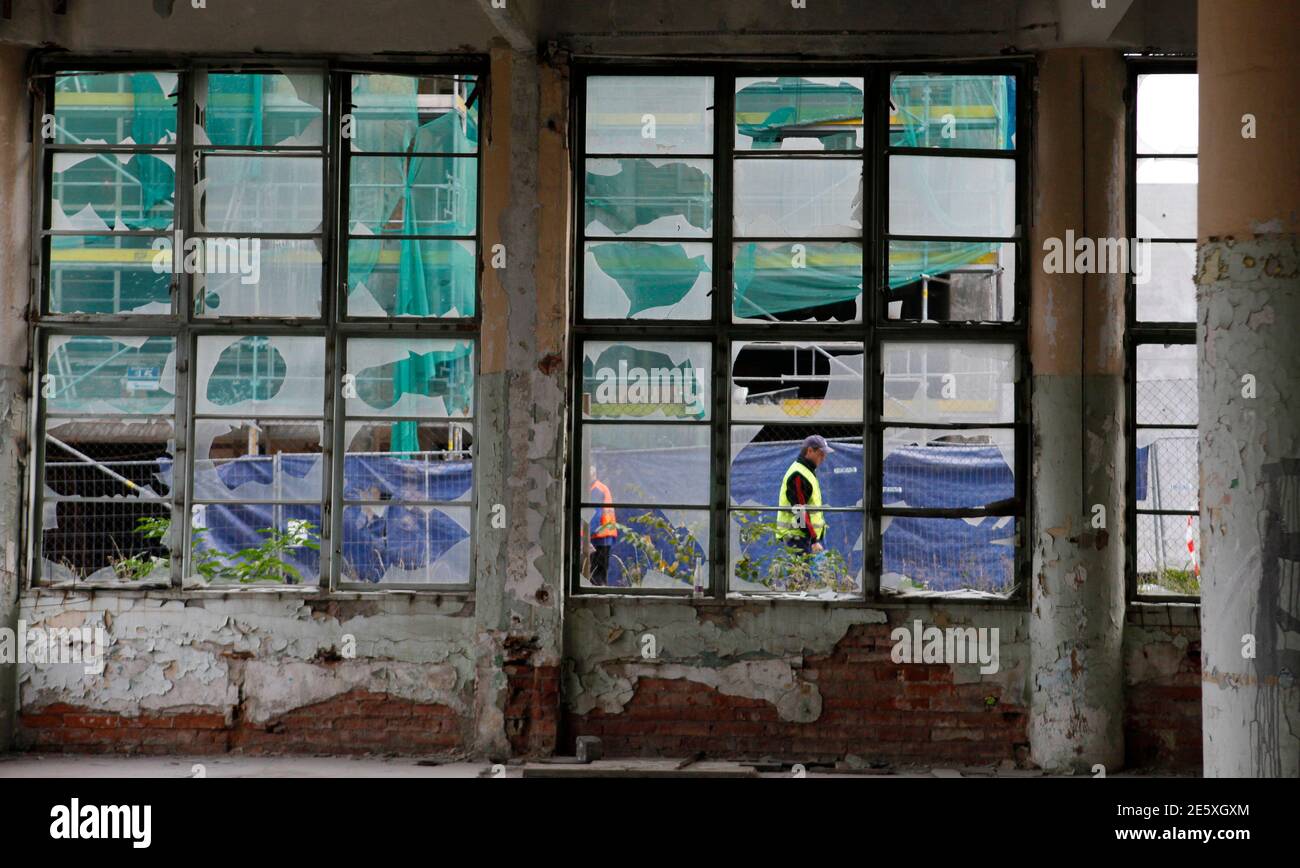 A worker walks past a damaged building in an area of Bata's former shoe factory complex in Zlin, October 23, 2012, which Tomas Bata created as part of a 'utopian' factory village for his workers almost a century ago. A world war and four decades of communism has taken some of the shine off Zlin and dozens of the red-brick buildings in its giant factory complex had since fell into disrepair. Now public and private investors are in the final stages of a decade-old plan to restore the area. Picture taken October 23, 2012. REUTERS/Petr Josek (CZECH REPUBLIC - Tags: BUSINESS CONSTRUCTION CITYSPACE  Stock Photo