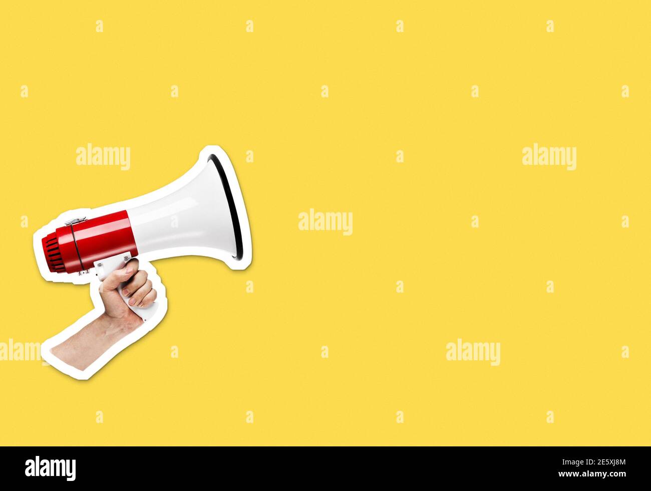 Hand holding megaphone on bright yellow background with plenty of copy space. Magazine collage cut out style Stock Photo