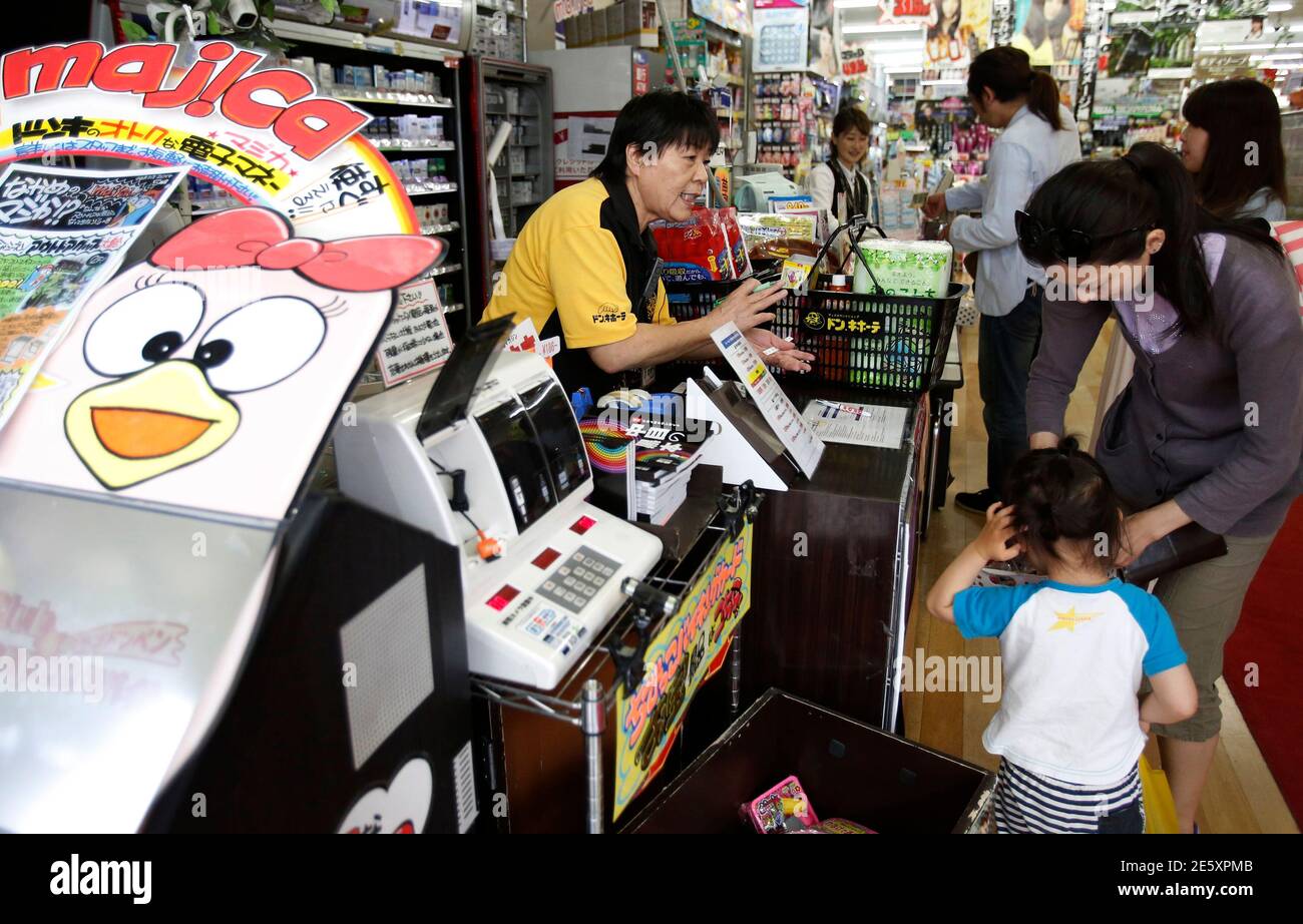Shoppers line up in front of cashiers at the Don Quijote's central branch  store in Tokyo May 28, 2014. Don Quijote and Uniqlo, two of Japan's most  successful mass-market retailers, aren't waiting