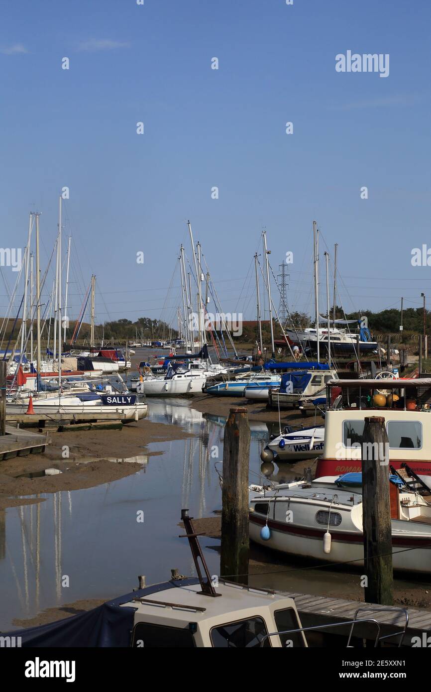 Moored boats on wharfe at Oare Creek at low tide  Faversham, Kent, England, United Kingdom Stock Photo