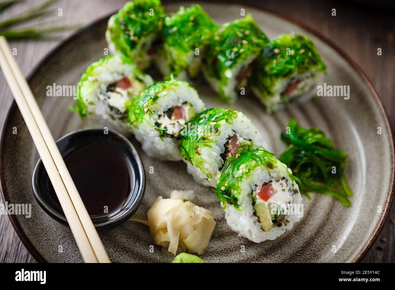 Sushi maki rolls with cucumber, avocado, tomato, creamy cheese, chuka wakame  on a plate with chopsticks, soy sauce, wasabi and ginger. Japanese Stock  Photo - Alamy