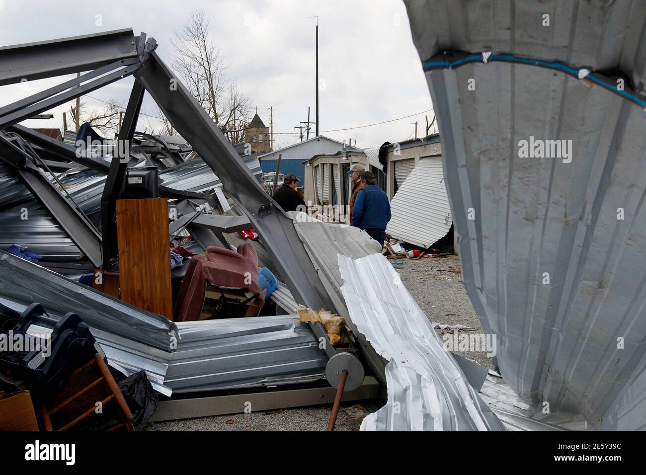 Residents look through twisted steel for their belongings at a self-storage facility in Henryville, Indiana March 4, 2012. Calm weather gave dazed residents of storm-wracked towns a respite early on Sunday as they dug out from a chain of tornadoes that cut a swath of destruction, killing at least 39 people.   REUTERS/John Sommers II (UNITED STATES - Tags: DISASTER ENVIRONMENT) Stock Photo