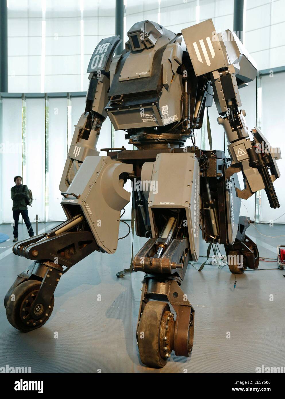 A man looks at a giant "Kuratas" robot at an exhibition in Tokyo November  28, 2012. The four-meter-high, limited edition, made-to-order robot is  controlled through a pilot in its cockpit, or via