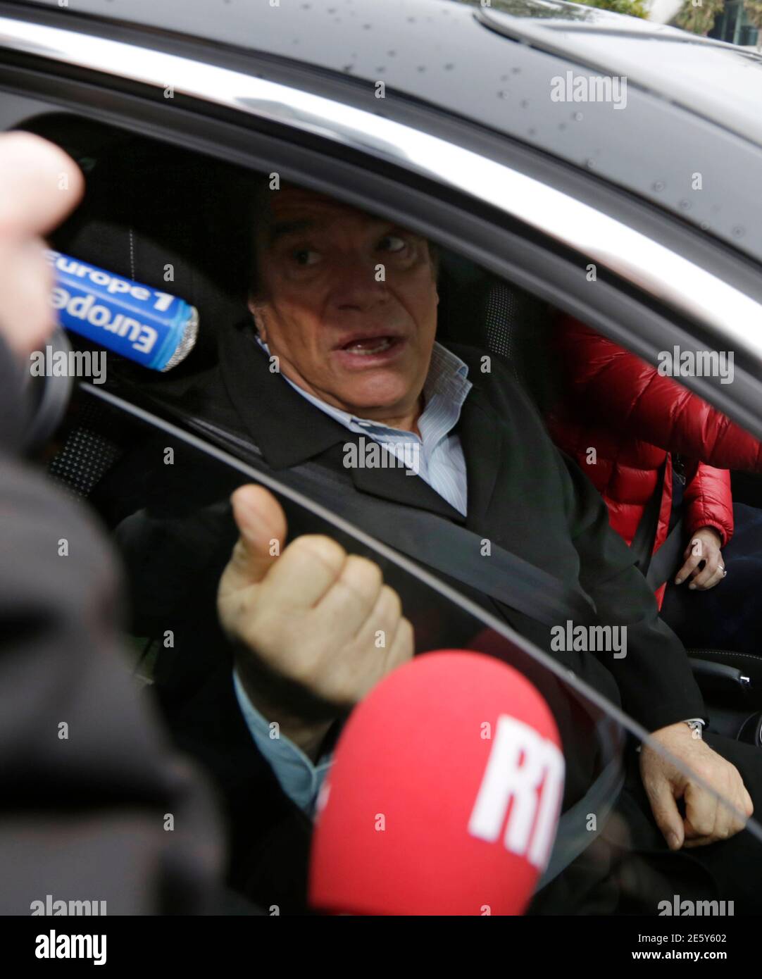 French businessman Bernard Tapie speaks to the media from his car as he  leaves the headquarters of local daily newspaper 'Nice Matin' in Nice  December 20, 2012. Tapie takes over ownership of