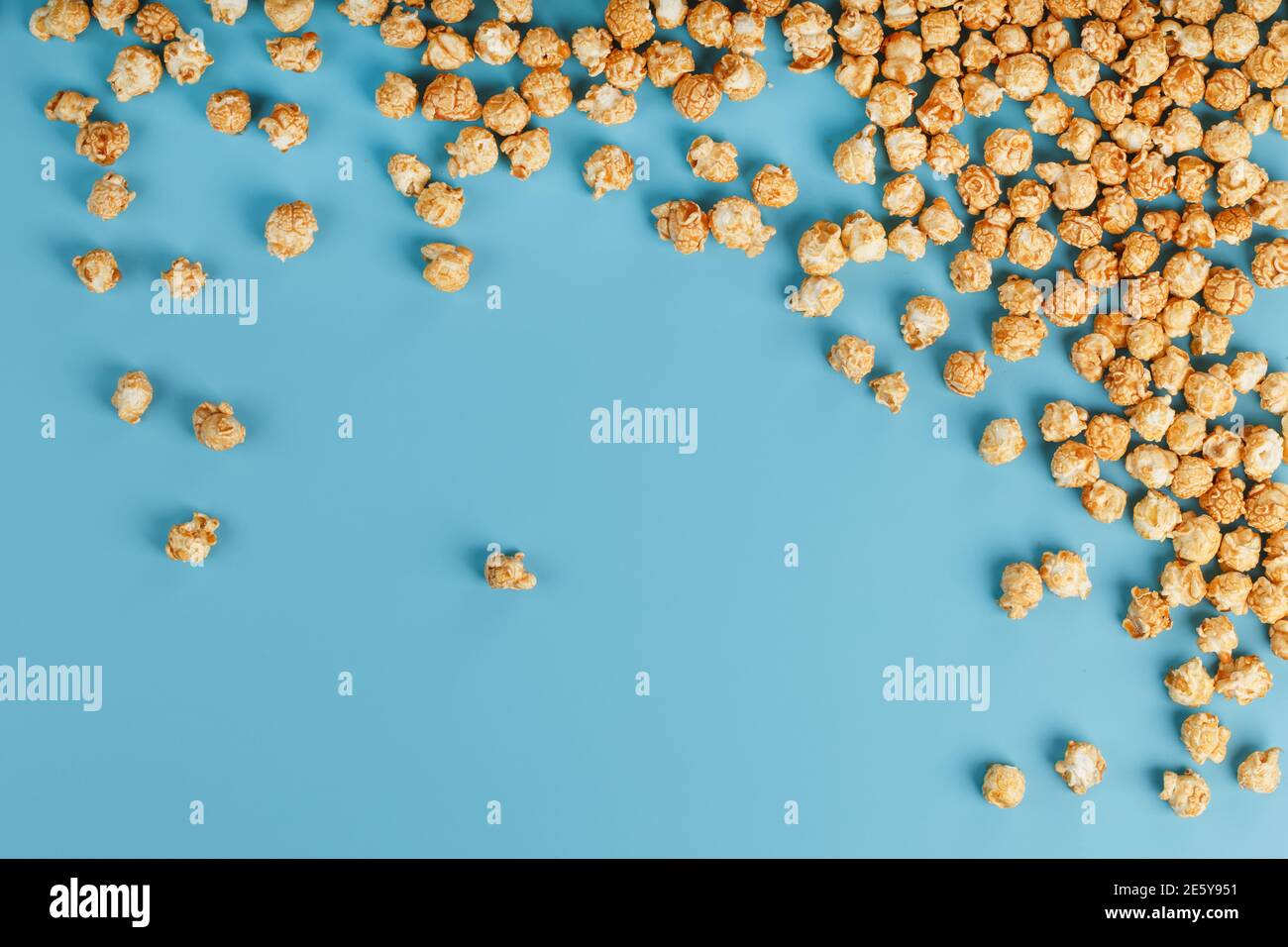 Caramel popcorn by a ripple on a blue background, in the form of a frame. Delicious catch for the films of movies, serials, cartoons. Free rightful, c Stock Photo