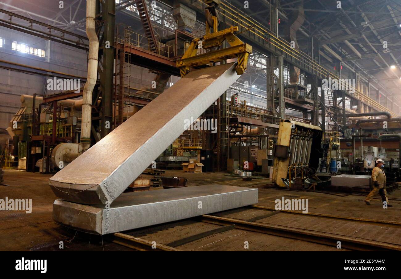 An employee operates a loader to transport an aluminium ingot weighing 15 tons (33,070 pounds) at the foundry shop of the Rusal Krasnoyarsk aluminium smelter in the Siberian city of Krasnoyarsk July 8, 2014. Russian aluminium giant Rusal has approval for a $3.6 billion debt restructuring deal from another of its creditors German financial services provider Portigon AG, two sources familiar with decision said. The move brings Rusal, the world's largest aluminium producer, a step closer to reaching a deal that will revise the terms of its syndicated debt, giving the company time to turn itself a Stock Photo