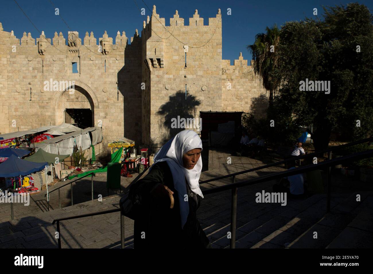 A woman walks past by the outer wall of the Old City, close to Damascus Gate, in Jerusalem July 25, 2014. REUTERS/Siegfried Modola (JERUSALEM - Tags: SOCIETY) Stock Photo