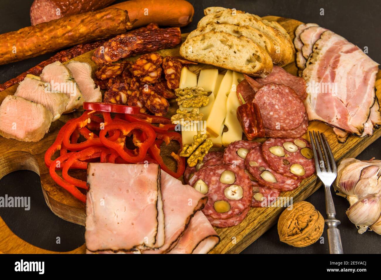 Various kind types of salami, speck and sausages on a wooden table. Fat
