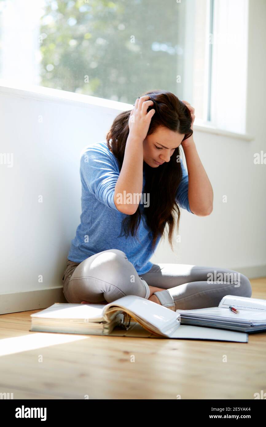 Student girl sat on the floor studying Stock Photo