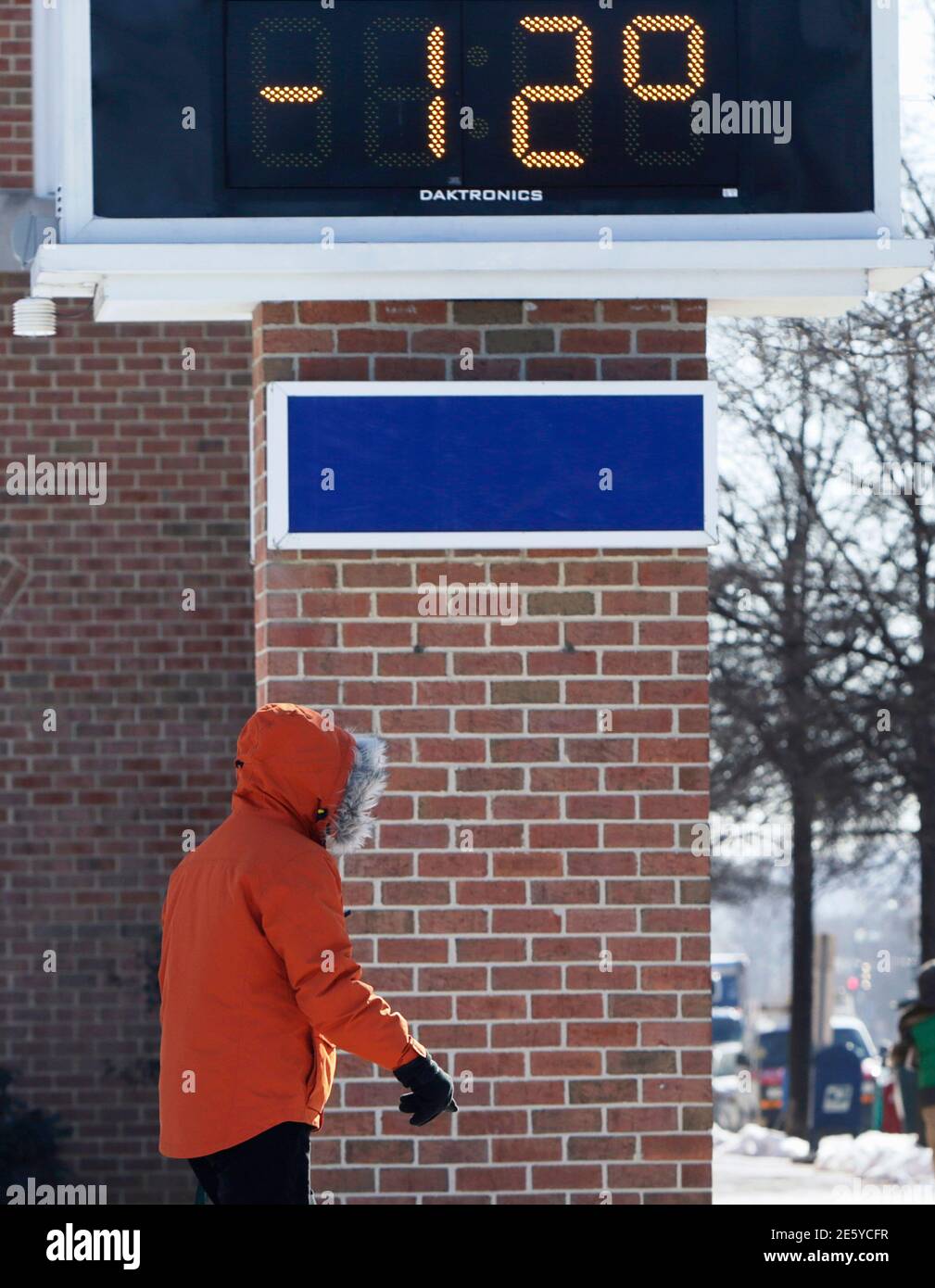 A bundled up pedestrian walks by a bank temperature sign which registered  minus 12 degrees Fahrenheit (minus 24 degrees Celsius) during a frigid cold  morning in Washington February 20, 2015. Millions of