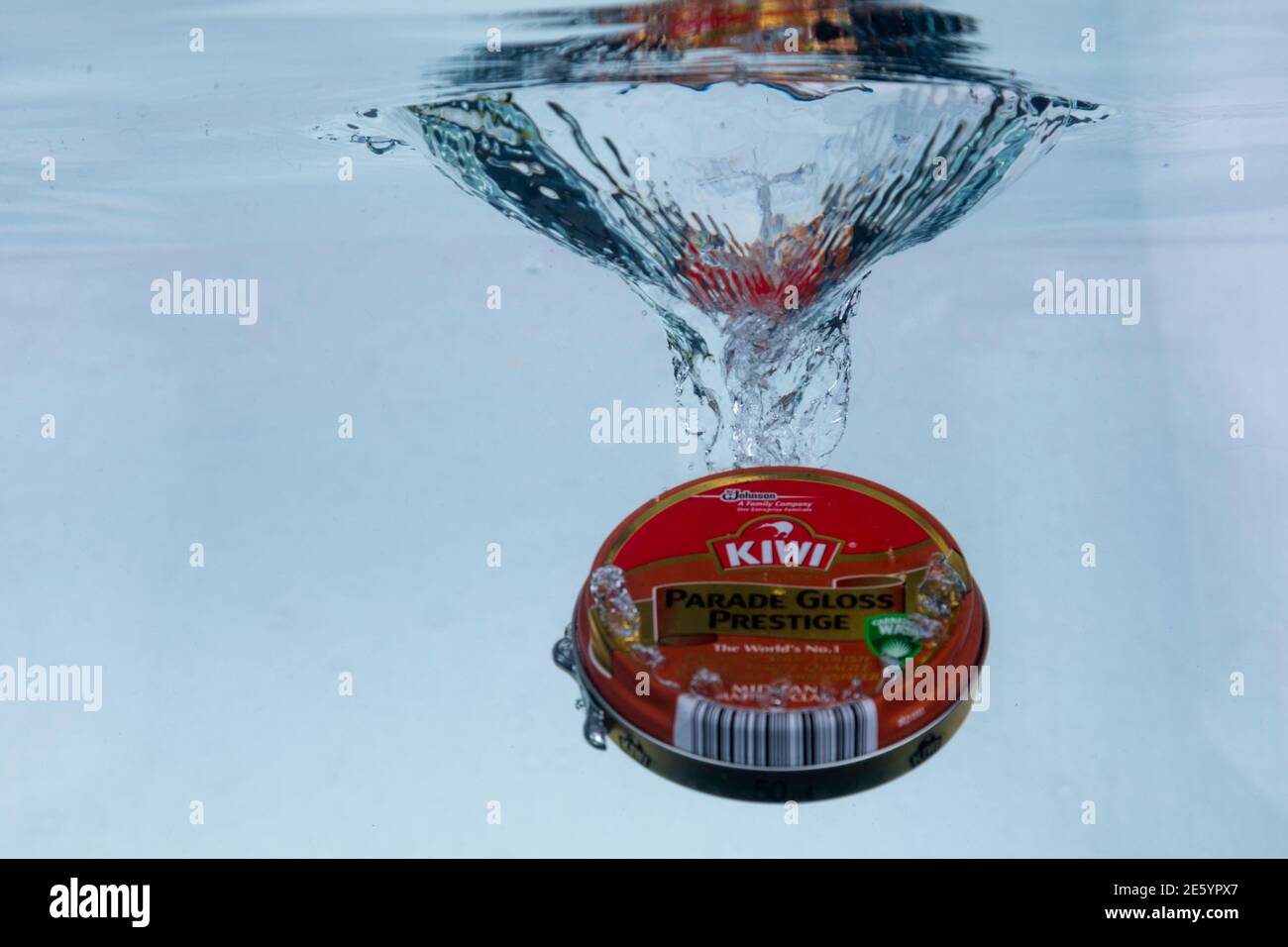 Hi-speed shot of a tin of Kiwi shoe polish dropping into water. Ultra hi-speed  of 1/5000th of a second Stock Photo - Alamy