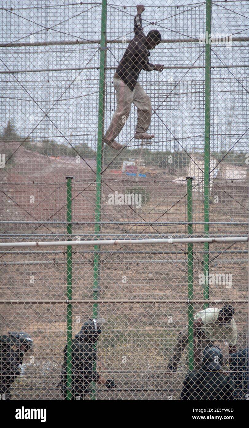 African Migrants Climb A Border Fence As Spanish Civil Guard Officers Stand Under Them During A Latest Attempt To Cross Into Spanish Territory Between Morocco And Spain S North African Enclave Of Melilla