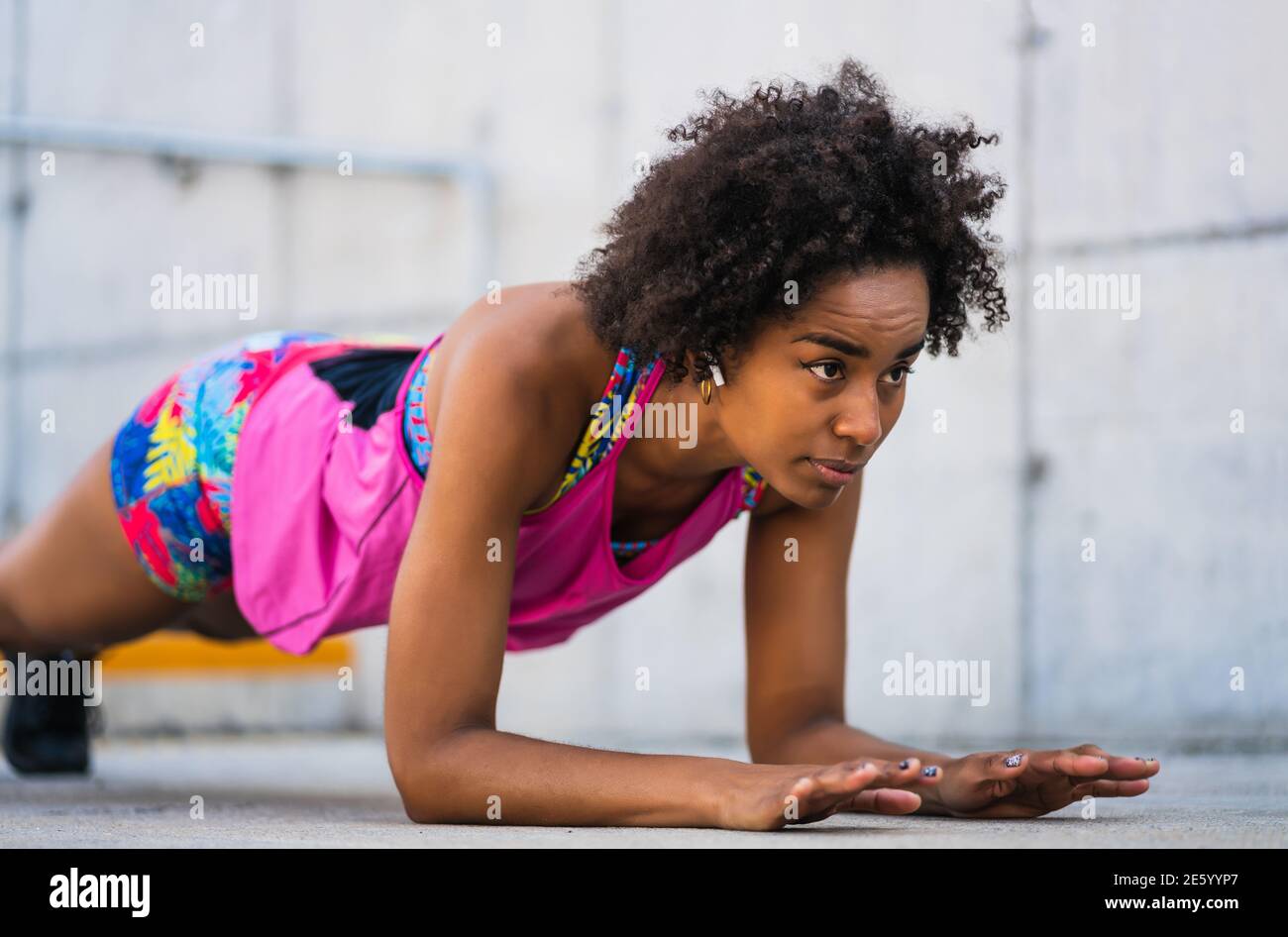 Afro athlete woman doing pushups outdoors. Stock Photo