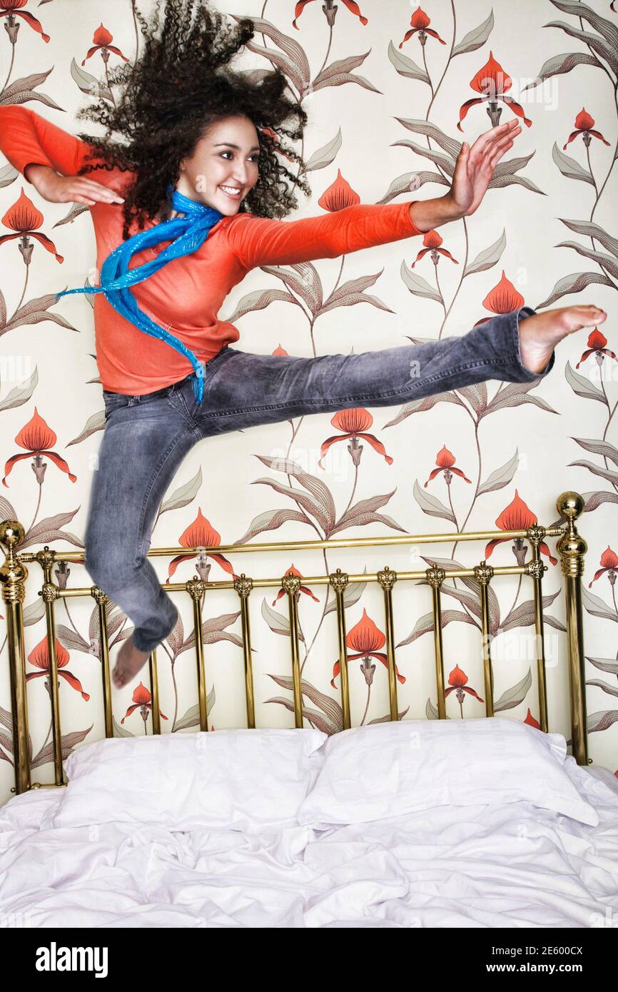 Portrait of a smiling teenage girl jumping on bed Stock Photo Alamy