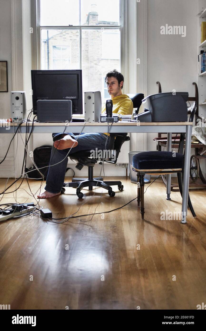 Young man working on computer in study room at home Stock Photo