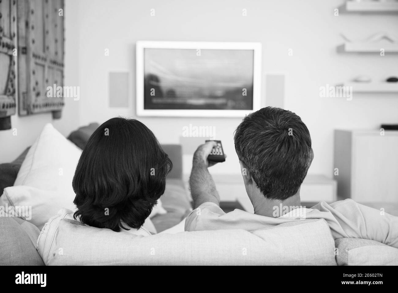 Black and white photo of couple watching television on lockdown Stock Photo