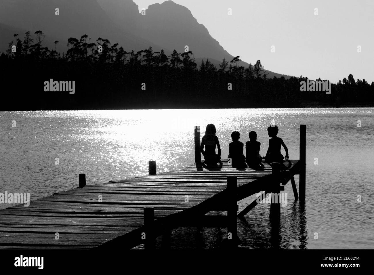 Black and white photo of happy family on pier Stock Photo