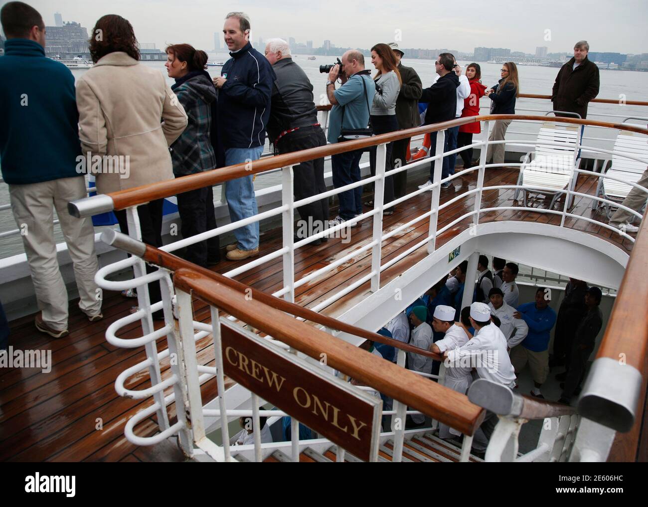 Passengers and crew aboard the Titanic Memorial Cruise stand on the aft  decks of the MS Balmoral to view the skyline while arriving in New York  City April 19, 2012. The ship