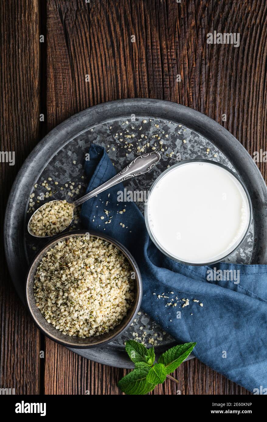 A bottle of freshly made dairy free hemp seed milk for vegans on wooden backdrop, decorated with mint Stock Photo