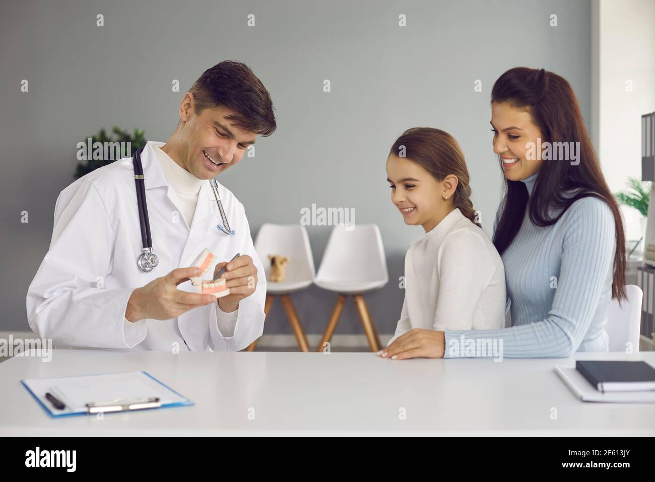 Pediatric dentist or oral hygienist teaching little girl to brush teeth properly Stock Photo