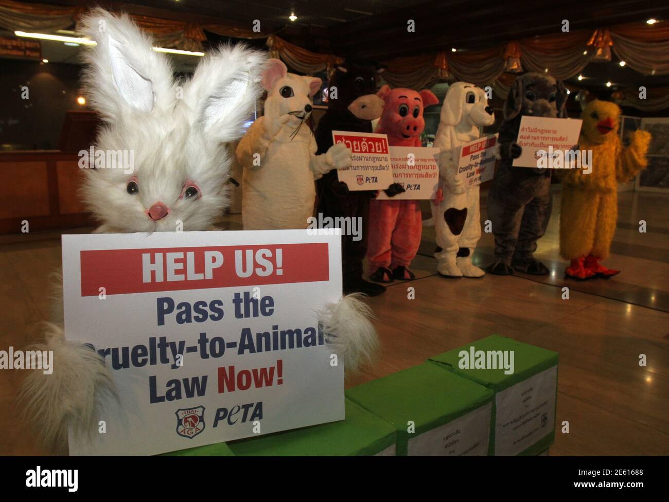Members of People for the Ethical Treatment of Animals (PETA) and Thai  Animal Guardians Association (Thai AGA) who are dressed as animals hold a  banner during a protest at Parliament House in