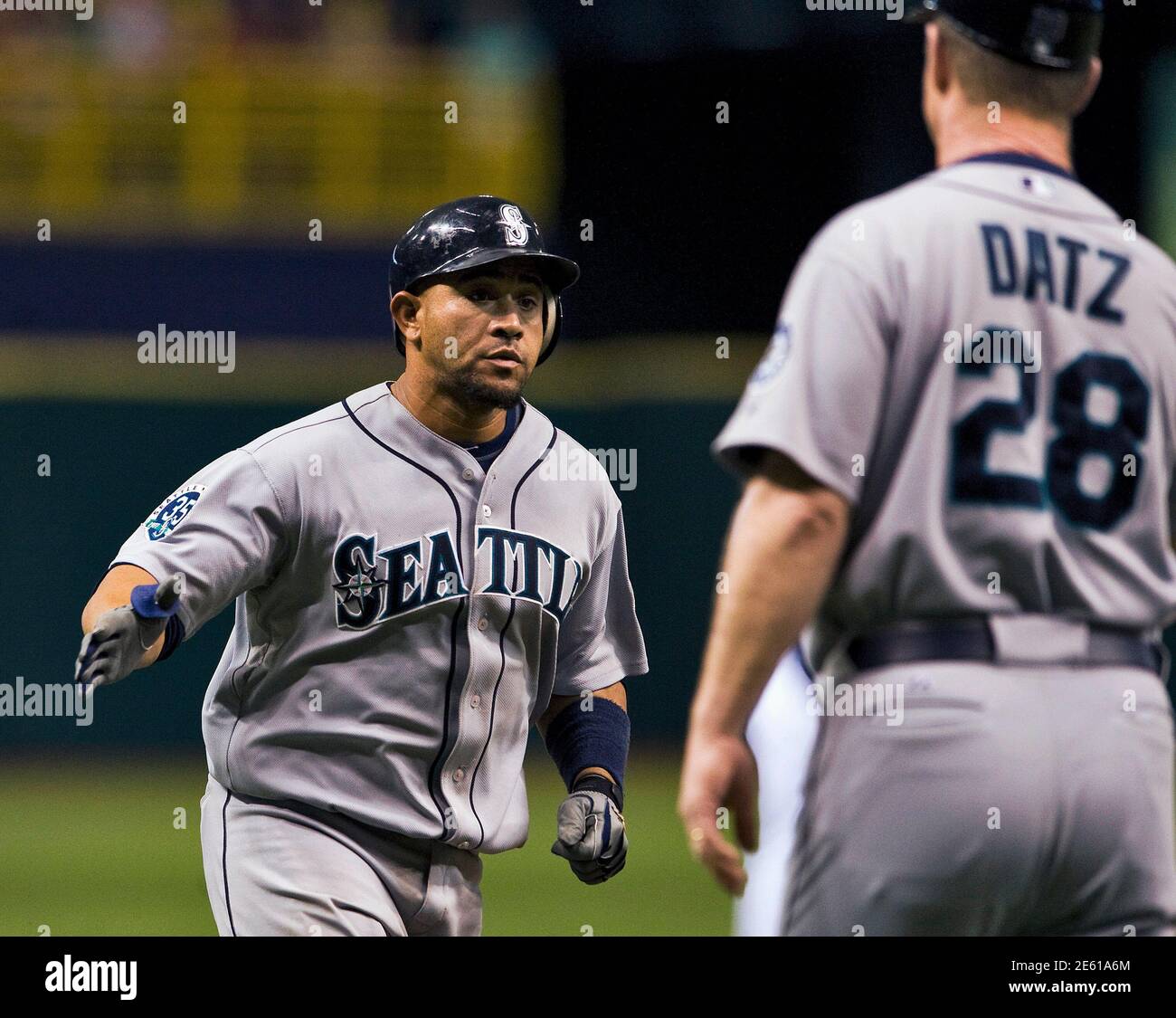 Seattle Mariners third base coach Jeff Datz (28) congratulates Miguel Olivo  after his solo home run off Tampa Bay Rays starter Jeremy Hellickson,  during the second inning of their MLB American League