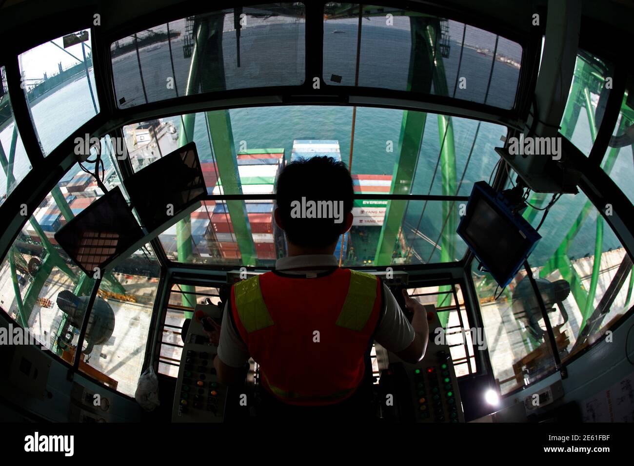 A crane operator unloads containers from a ship at a PSA International port terminal in Singapore September 27, 2013. Connected to more than 600 ports in some 120 countries, Singapore is one of the world's busiest shipping hubs, and is often called the gateway to Asia. It plans to increase its total capacity dramatically as it competes with other massive ports in the region such as Shanghai, Hong Kong and Shenzhen in China and Busan in South Korea. Picture taken September 27, 2013. REUTERS/Edgar Su (SINGAPORE - Tags: MARITIME BUSINESS SOCIETY) ATTENTION EDITORS: PICTURE 13 OF 18 FOR PACKAGE ' Stock Photo