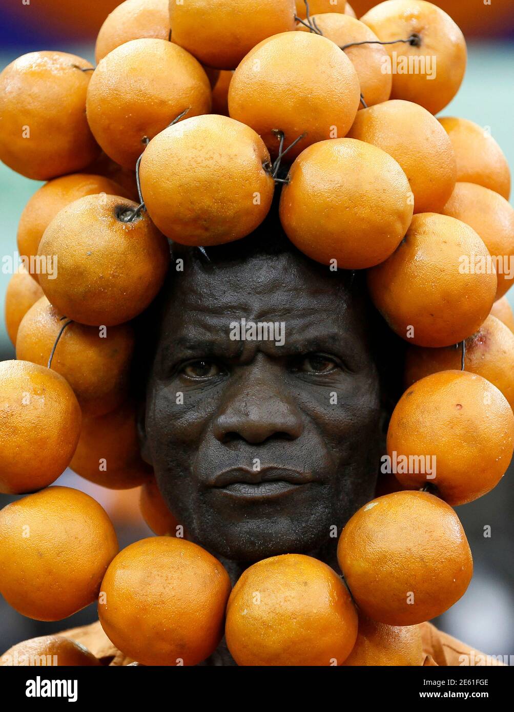 A supporter of the Orange Democratic Movement (ODM) party adorned with oranges on his head attends their National delegates convention to elect new party national office bearers in Kenya's capital Nairobi, February 28, 2014. Elections for the Orange Democratic Party were thrown into disarray on Friday afternoon after a group demanded the production of registers, before turning violent, local media reported. REUTERS/Thomas Mukoya (KENYA - Tags: POLITICS ELECTIONS TPX IMAGES OF THE DAY) Stock Photo