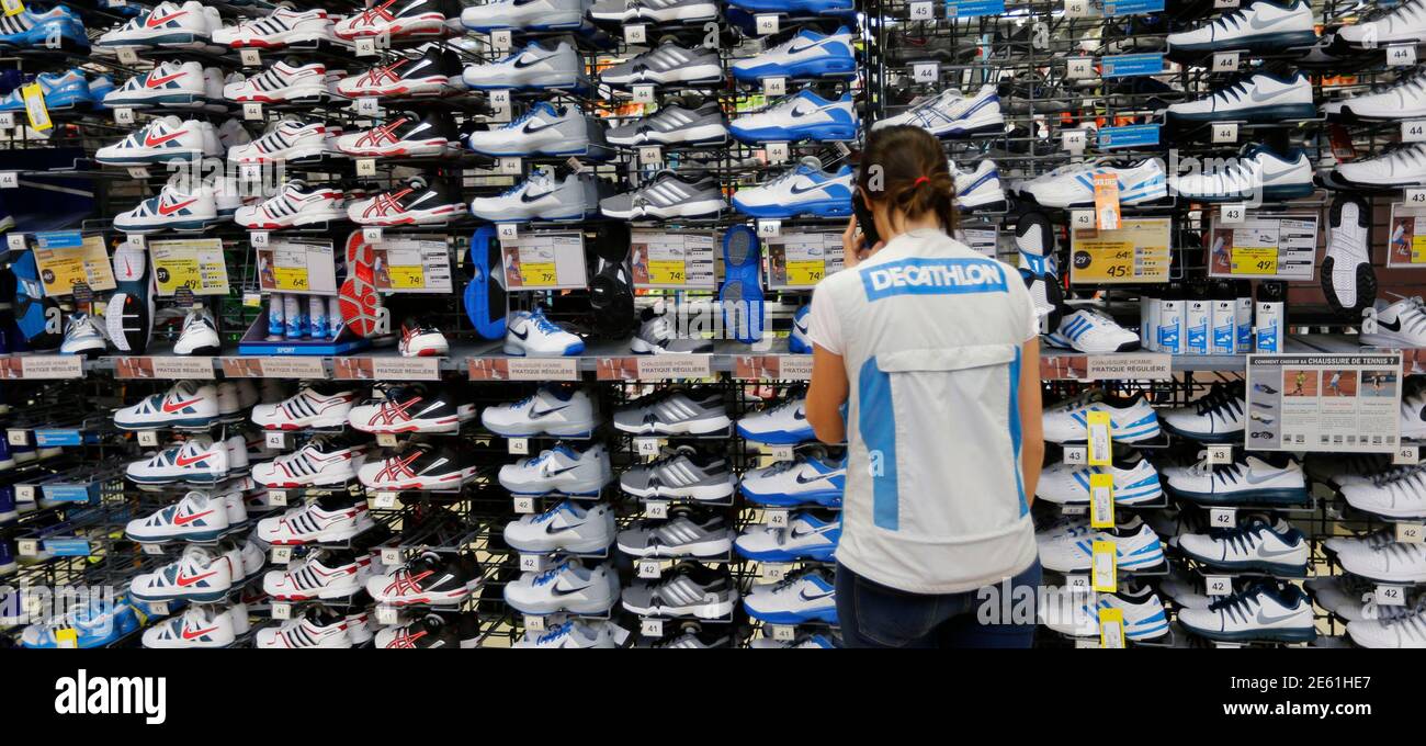 An employee works in the sport shoes aisle at the French sports equipment  and sportswear company Decathlon store in Merignac near Bordeaux July 10,  2014. The group, number one in French distribution