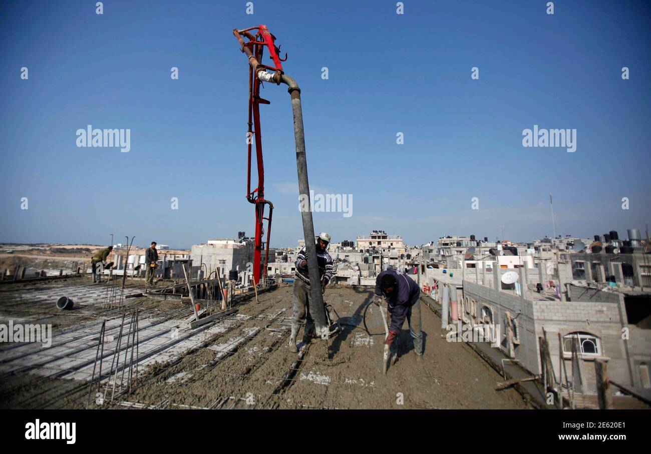 Palestinian labourers work at a construction site in Rafah in the southern Gaza Strip January 2, 2013. Israel eased its blockade of Gaza on Sunday, allowing a shipment of gravel for private construction into the Palestinian territory for the first time since Hamas seized control in 2007.  REUTERS/Ibraheem Abu Mustafa (GAZA - Tags: POLITICS BUSINESS CONSTRUCTION) Stock Photo