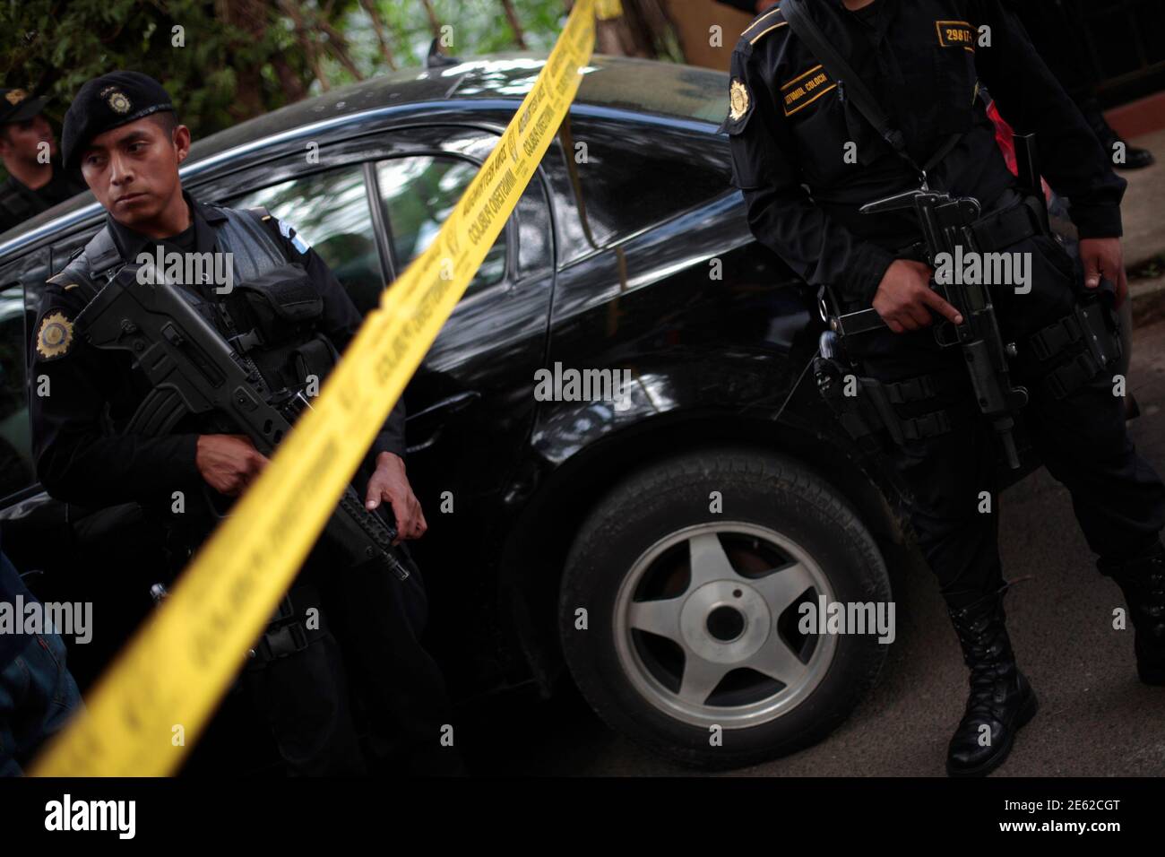 Police Officers Stand Guard Next To A Car Not Pictured With Bullets Holes On Its Exterior Outside The Stadium Of Santa Catarina Pinula In The Outskirts Of Guatemala City July 22 2012