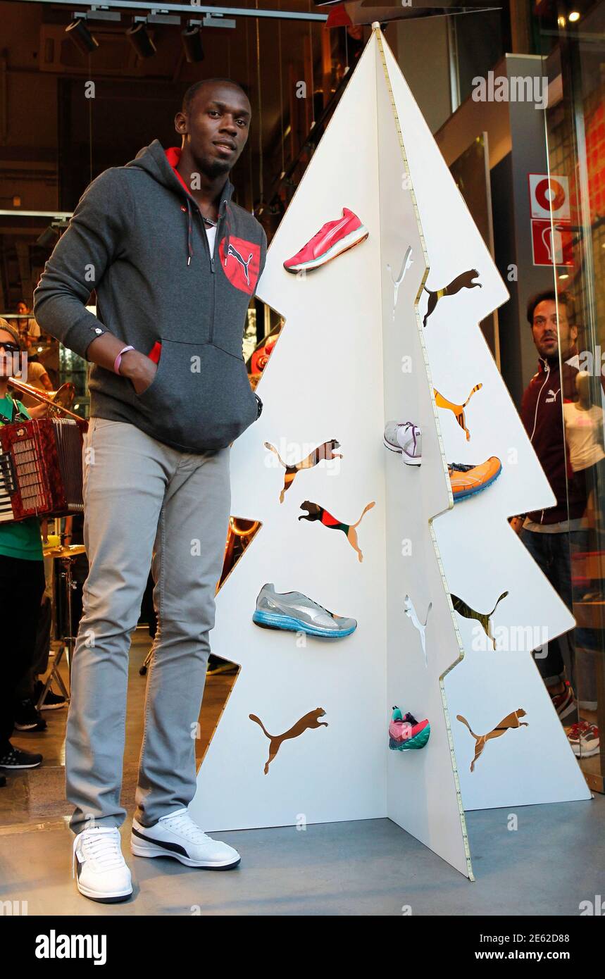 Jamaica's double Olympic champion sprinter Usain Bolt poses next to a  display in the form of a Christmas tree while inaugurating a Puma store in  Barcelona November 23, 2012. Bolt is on