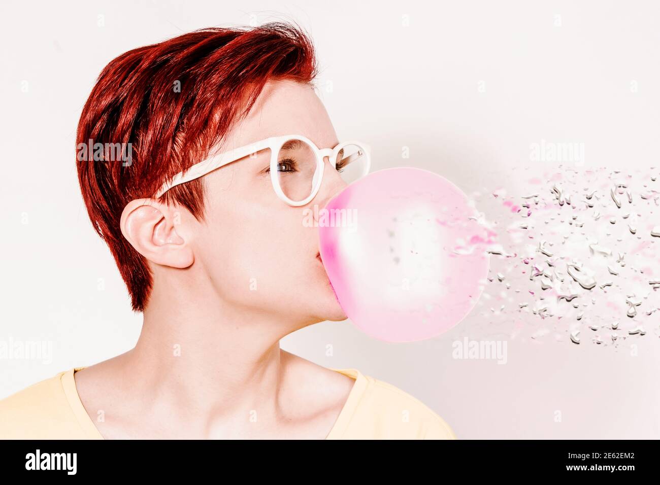 redhaired woman with glasses and big bubble of chewing gum with