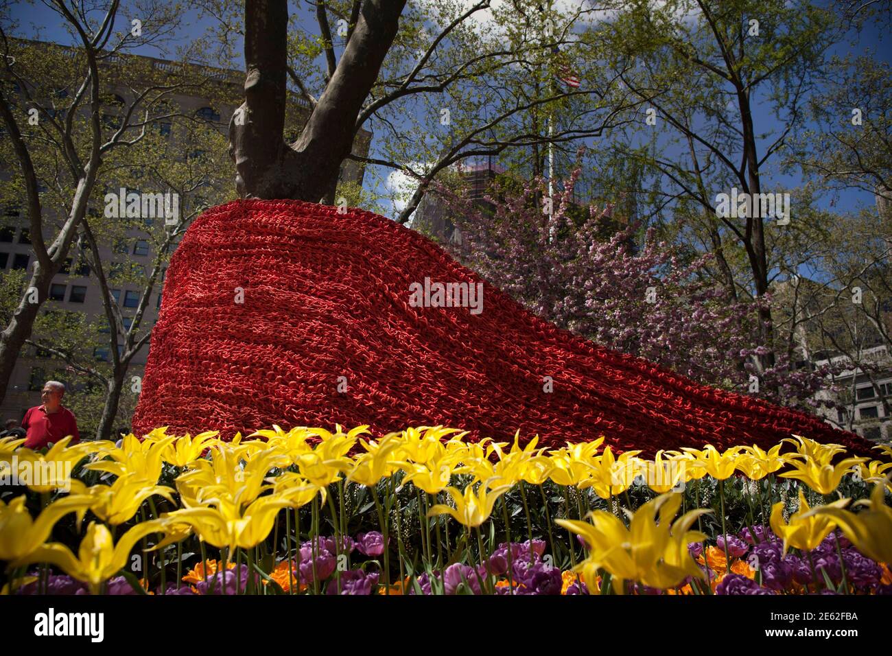 A man walks beside artist Orly Genger's art installation called 'Red, Yellow and Blue' (2013) in Madison Square Park, New York May 1, 2013. New York-based Genger presented her site-specific, large-scale art work, featuring colorfully-lined chambers of more than 1.4 million feet of painted, hand-knotted rope. REUTERS/Andrew Kelly (UNITED STATES - Tags: SOCIETY) Stock Photo