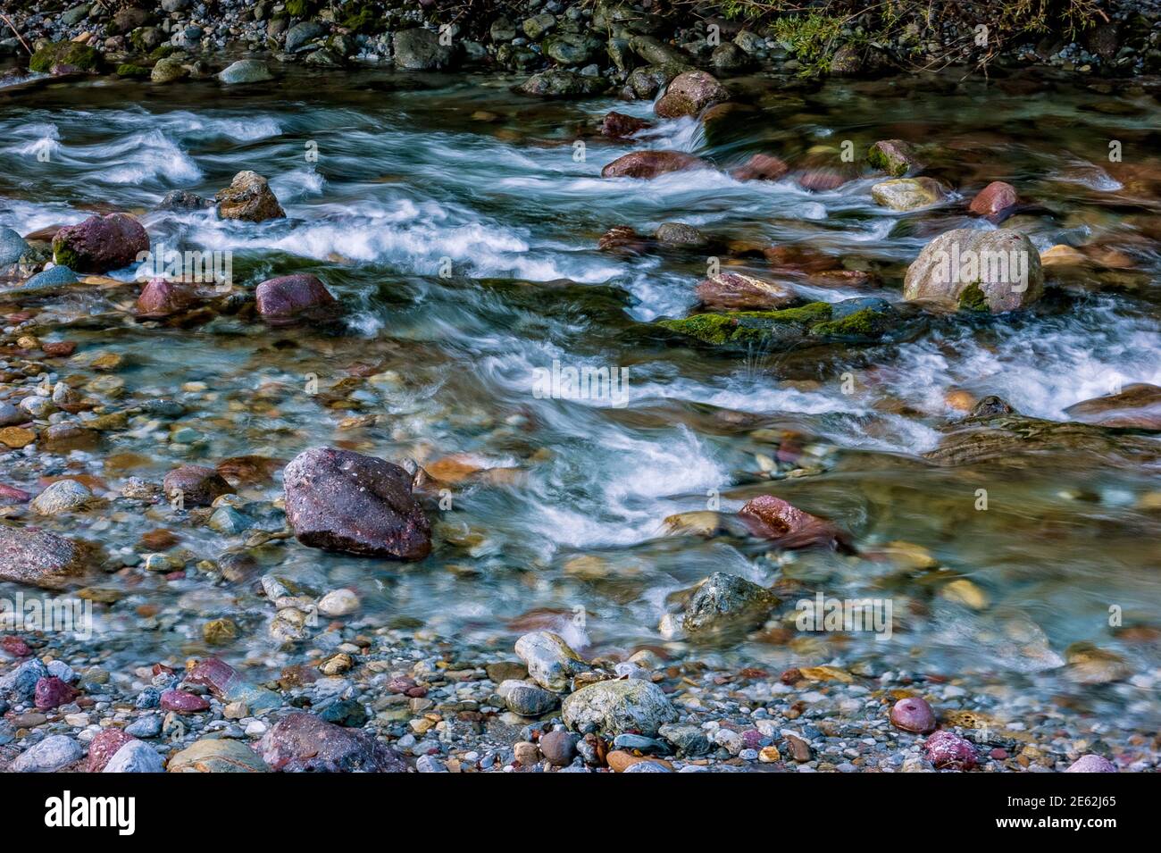 the impetuous flow of water between the stones of a torrent Stock Photo