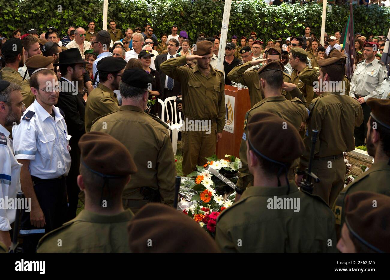 Israeli soldiers from the Golani Brigade salute beside the grave of their fallen comrade Max Steinberg during his funeral at Mount Herzl military cemetery in Jerusalem July 23, 2014. Steinberg, a 23 year-old American from California's San Fernando Valley, was among 13 Israeli Defense Forces soldiers killed on Sunday during fighting in Gaza. REUTERS/Siegfried Modola (JERUSALEM - Tags: CONFLICT POLITICS CIVIL UNREST MILITARY) Stock Photo