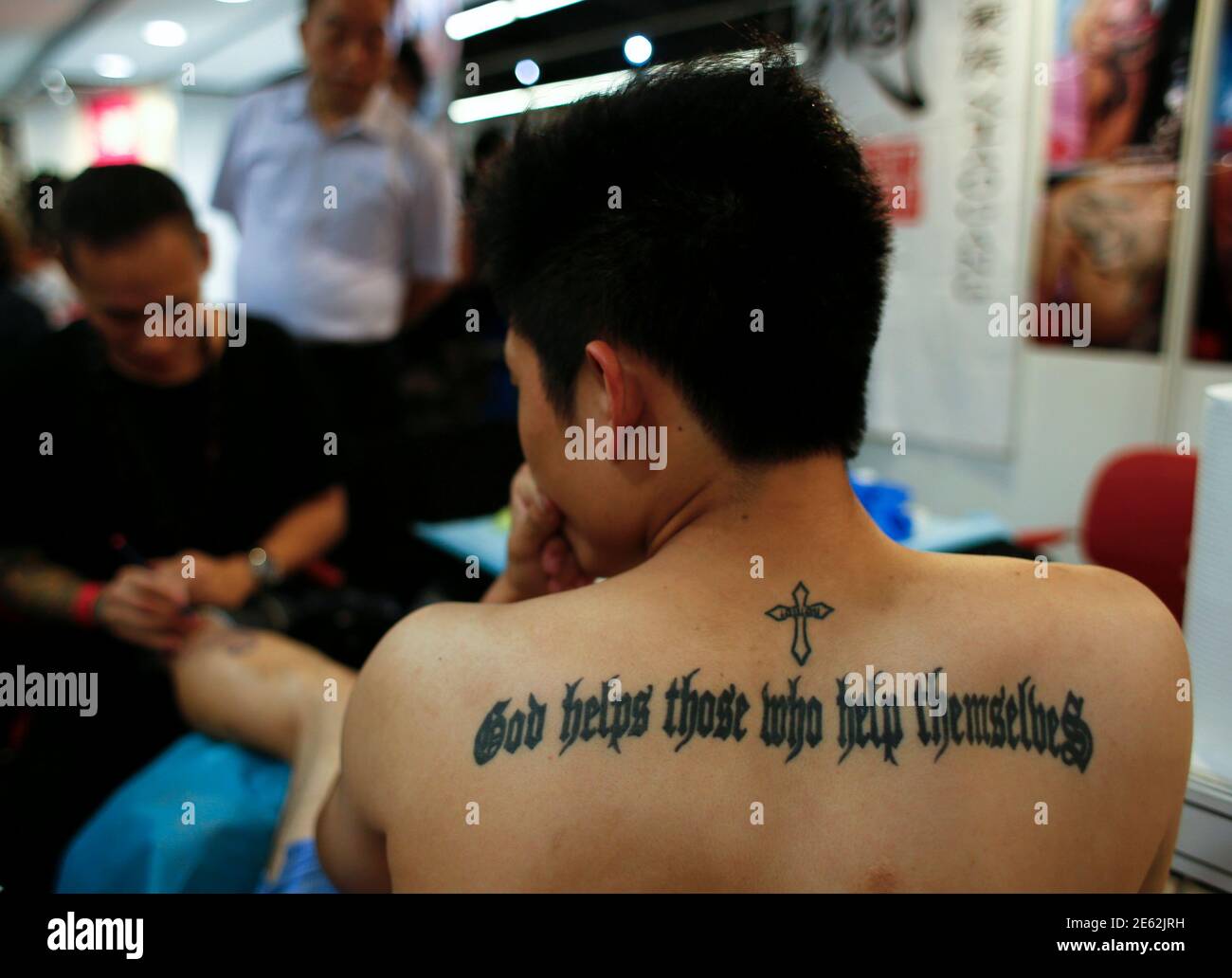 A man receives tattoo at the 2nd International Hong Kong China Tattoo  Convention in Hong Kong August 22, 2014. The territory held its second  international tattoo convention on Friday, hoping to pin