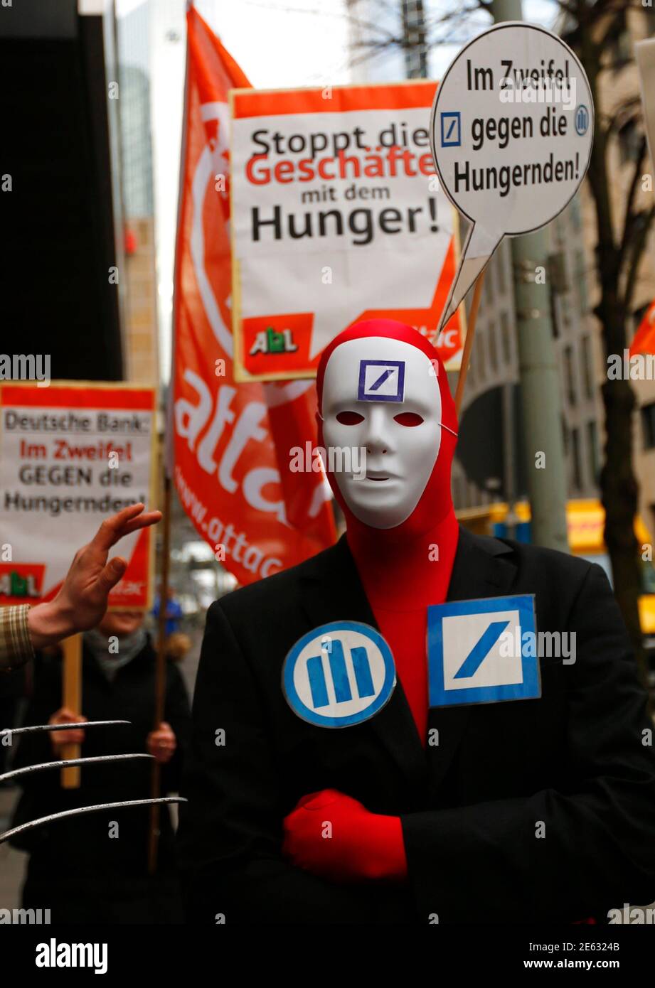A demonstrator with a placard reading 'in doubt against the hungry' stands in front of the headquarters of Germany's largest business bank, Deutsche Bank, as he demonstrates against speculations with food prices before the bank's annual news conference in Frankfurt, January 31, 2013. Deutsche Bank posted a $3.5 billion quarterly loss as it took legal and restructuring charges aimed at drawing a line under past scandals and boosting its capital position in a tougher regulatory and trading environment.  REUTERS/Kai Pfaffenbach (GERMANY - Tags: BUSINESS CIVIL UNREST) Stock Photo