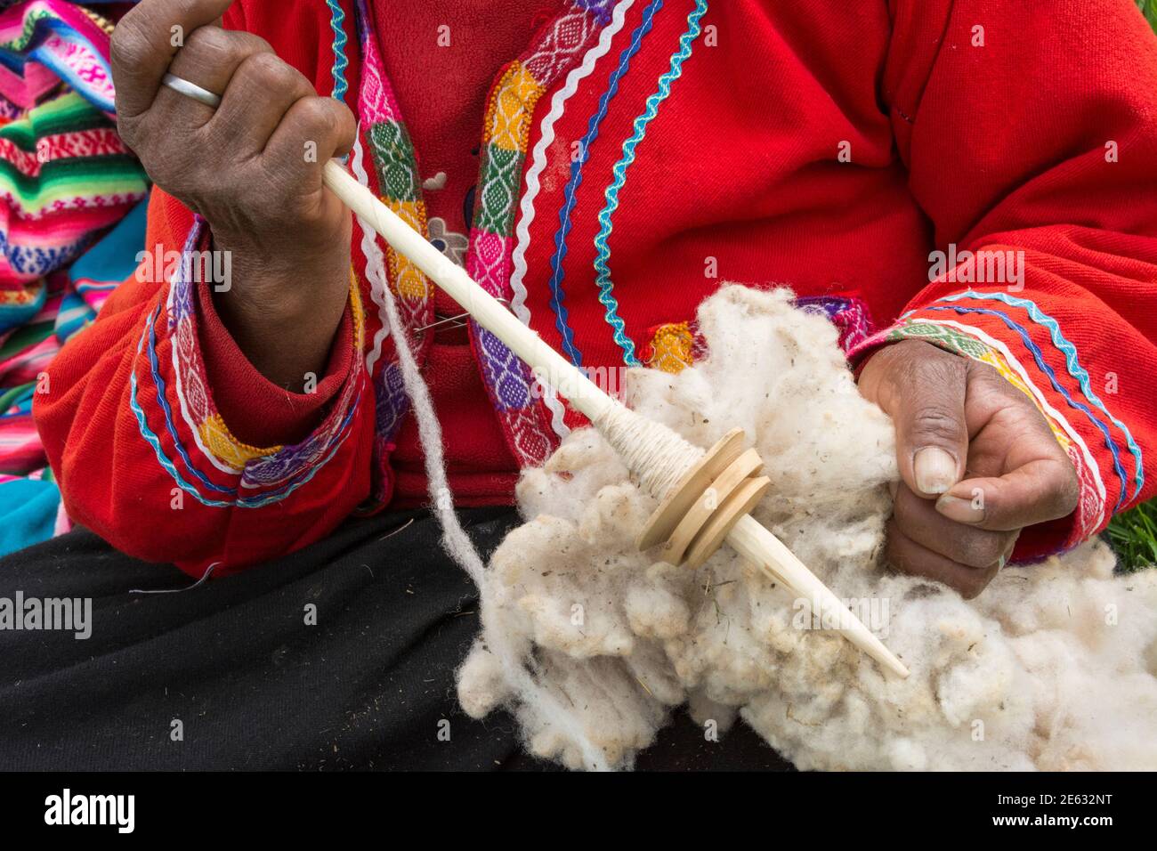 Quechua woman with alpaca wool and tool to spin it into yarn; El Parador de Moray, Sacred Valley, Peru. Stock Photo