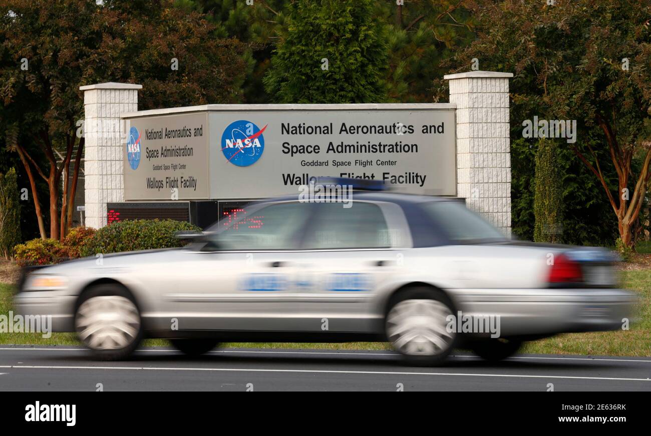 A police car passes a NASA Wallops Flight Facility entrance in Virginia October 29,  2014. On Tuesday night, the 14-story Antares rocket, built and launched by Orbital Sciences Corp, blasted off from here but burst into flames moments later.  REUTERS/Kevin Lamarque  (UNITED STATES - Tags: SCIENCE TECHNOLOGY) Stock Photo