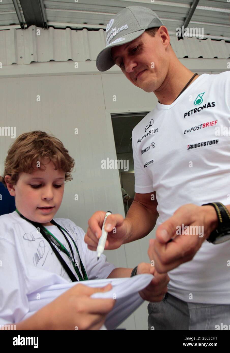 Mercedes Formula One driver Michael Schumacher of Germany signs an autograph at the Interlagos racetrack as teams prepared for Sunday's Brazilian GP F1 race in Sao Paulo November 4, 2010.                REUTERS/Paulo Whitaker (BRAZIL - Tags: SPORT MOTOR RACING) Stock Photo